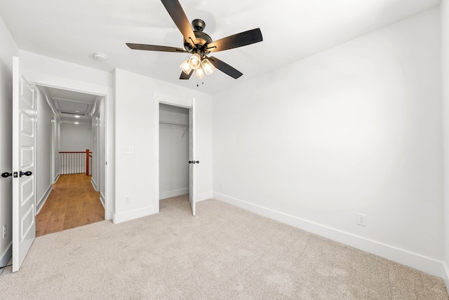 unfurnished bedroom with ceiling fan, light colored carpet, and a closet