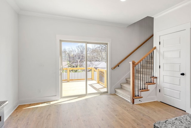 entrance foyer with light hardwood / wood-style floors and ornamental molding