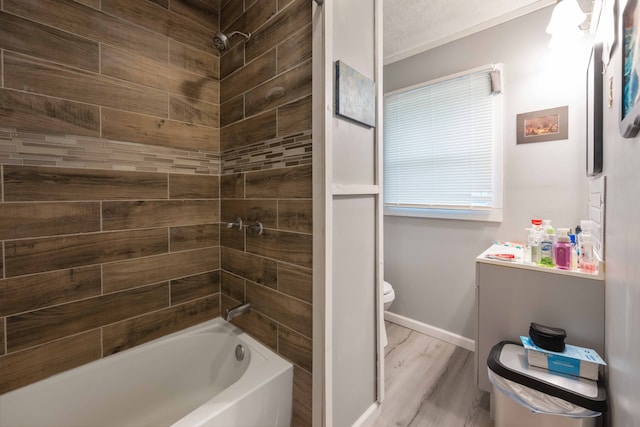 bathroom with wood-type flooring, tiled shower / bath combo, a textured ceiling, and toilet