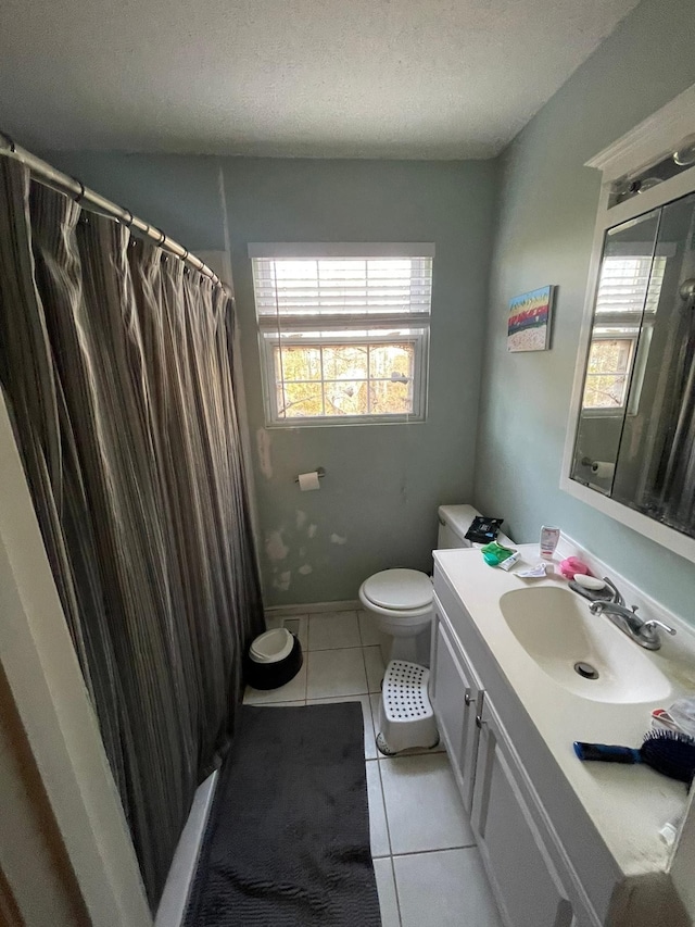 bathroom featuring tile patterned floors, vanity, a textured ceiling, and toilet