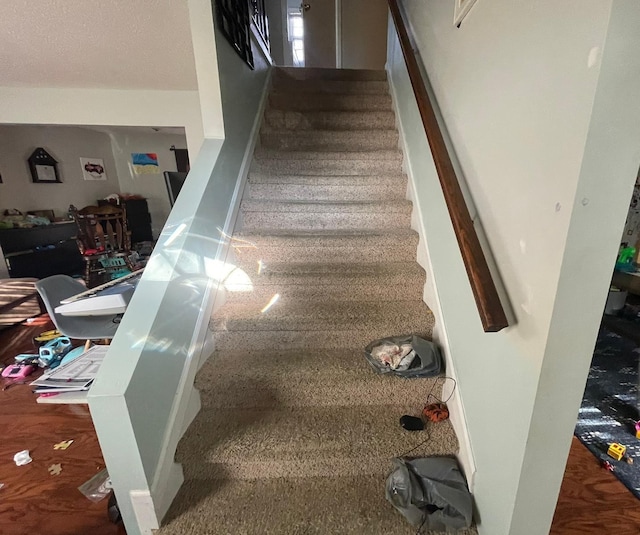 stairs with a textured ceiling