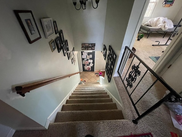 stairway with a notable chandelier and carpet floors