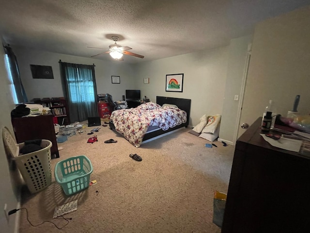 bedroom with ceiling fan, carpet floors, and a textured ceiling