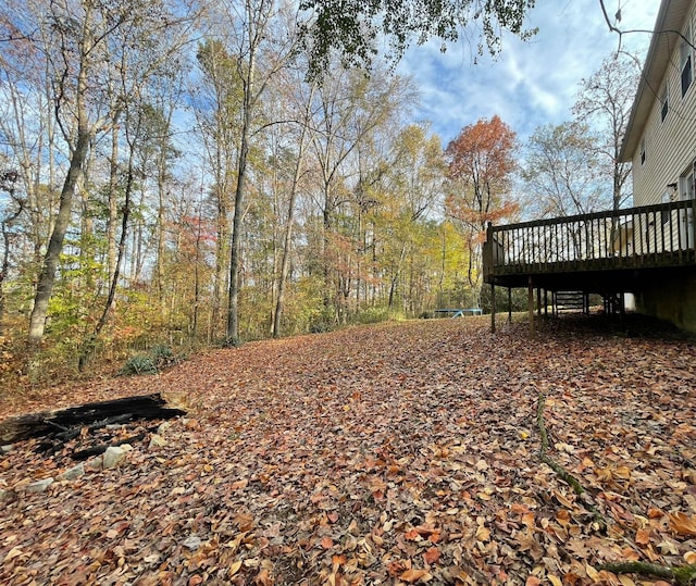 view of yard featuring a trampoline and a wooden deck