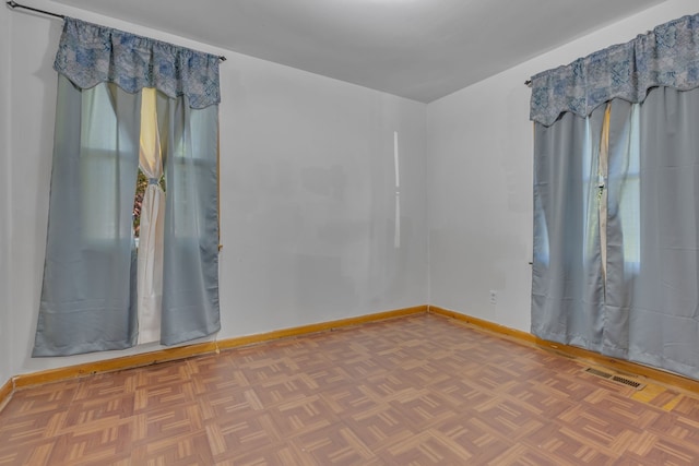 unfurnished room featuring parquet flooring