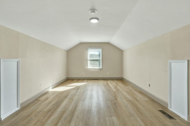 additional living space featuring light hardwood / wood-style floors and lofted ceiling