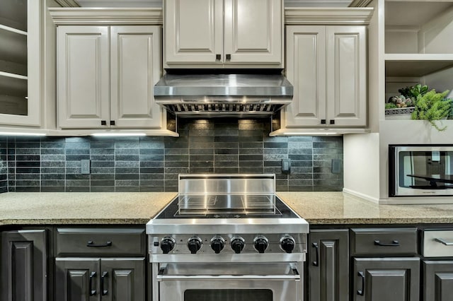 kitchen with stainless steel appliances, backsplash, light stone countertops, and extractor fan