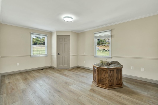 spare room featuring ornamental molding and light hardwood / wood-style flooring