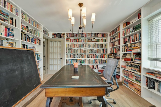 office area with light hardwood / wood-style flooring and a notable chandelier