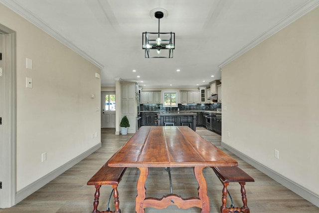 dining area featuring a notable chandelier, light hardwood / wood-style floors, and ornamental molding