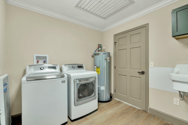 laundry area featuring cabinets, separate washer and dryer, water heater, crown molding, and light wood-type flooring