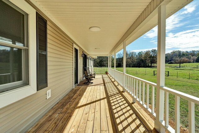 wooden terrace with covered porch and a yard