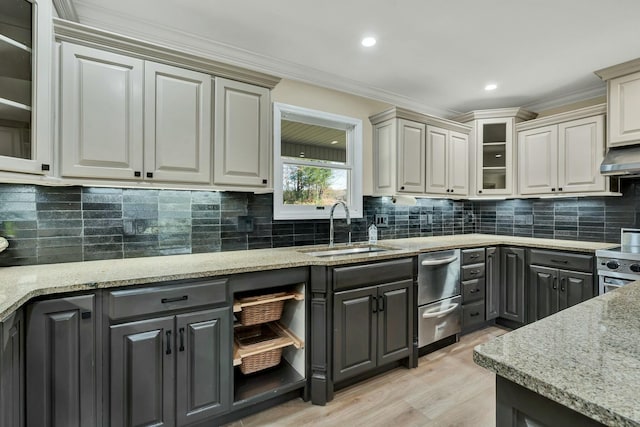 kitchen with light stone counters, extractor fan, crown molding, sink, and stainless steel range oven