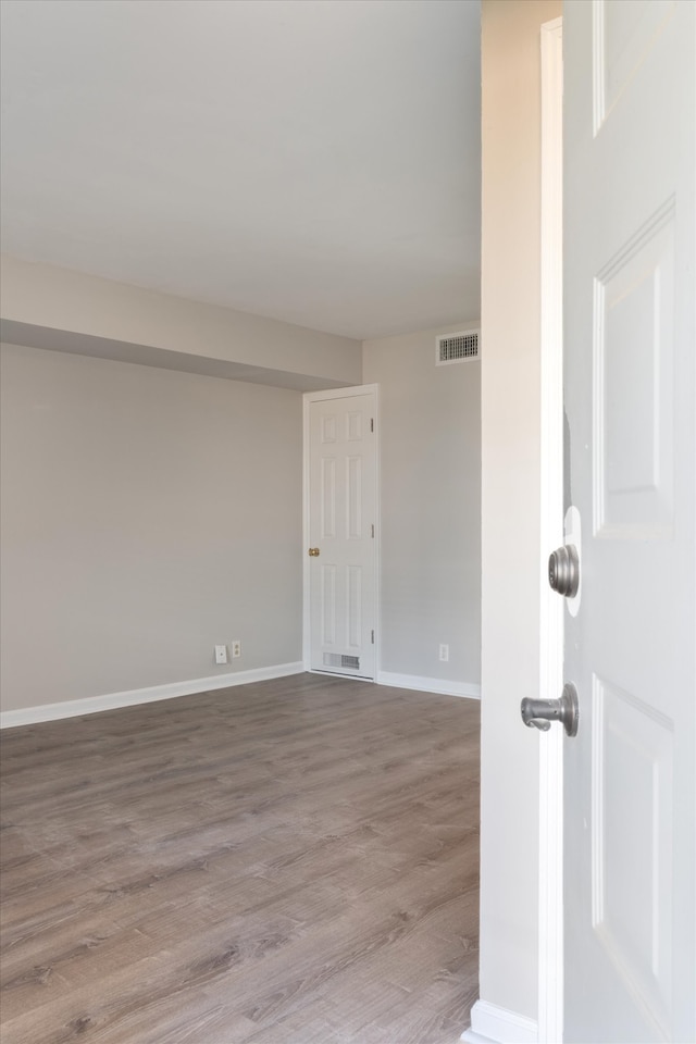 unfurnished room with wood-type flooring