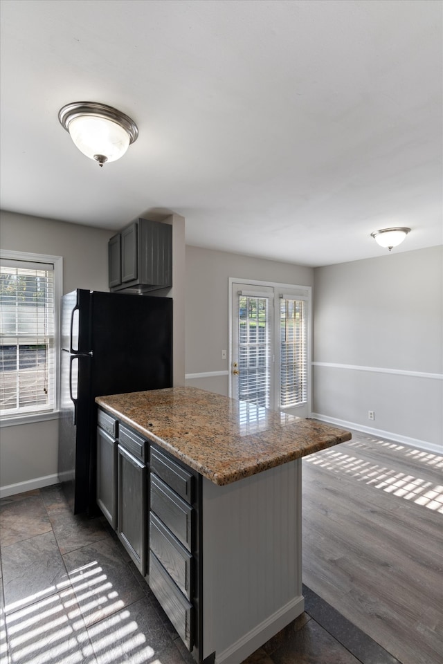 kitchen with dark wood-type flooring, stone countertops, and gray cabinetry