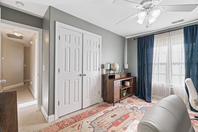 sitting room with ceiling fan and light colored carpet