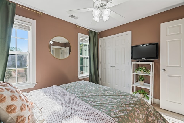 carpeted bedroom featuring ceiling fan and a closet