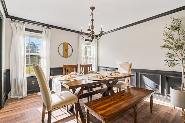 dining space with a chandelier, hardwood / wood-style flooring, and ornamental molding