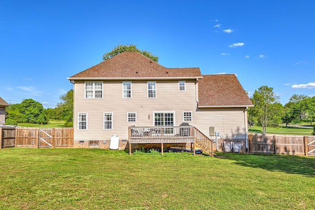 back of property with a deck and a yard