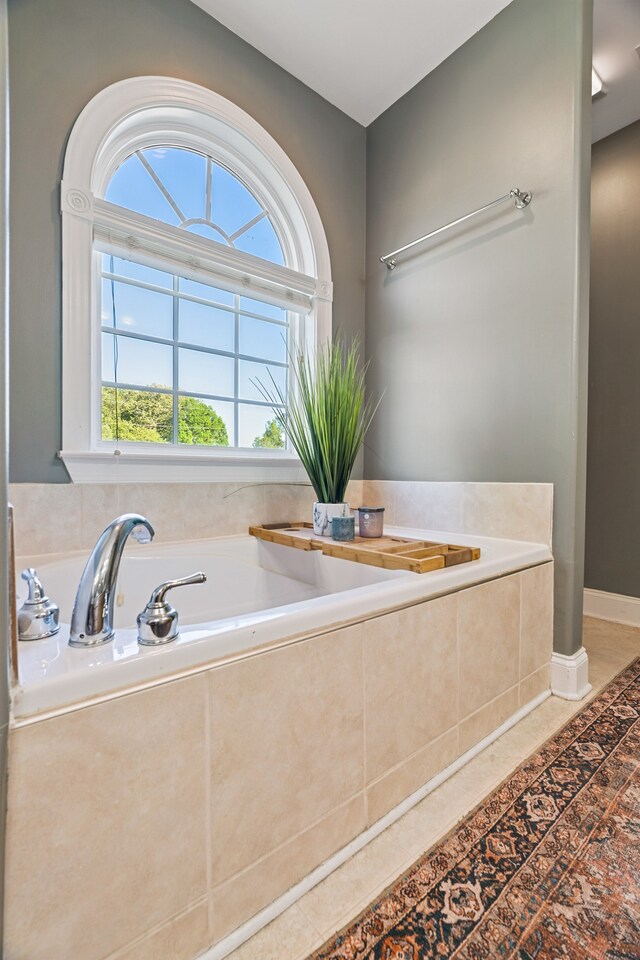 bathroom with tile patterned floors and tiled bath