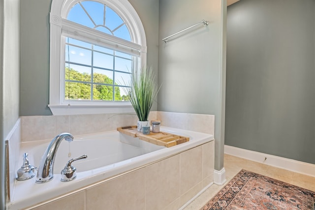 bathroom with tile patterned floors and a relaxing tiled tub