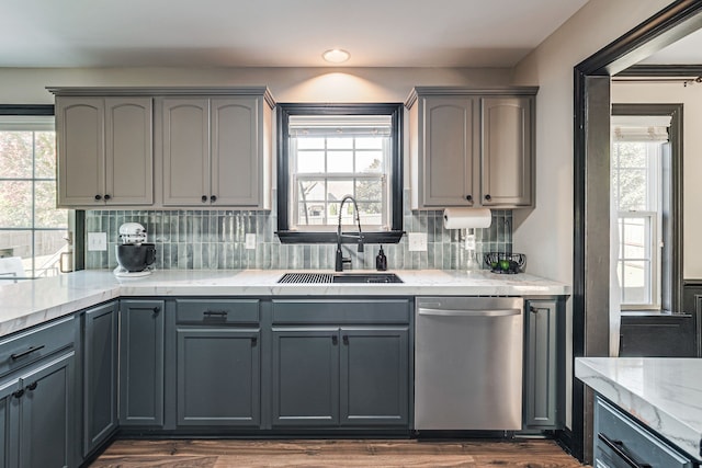 kitchen featuring dishwasher, gray cabinets, sink, and a wealth of natural light