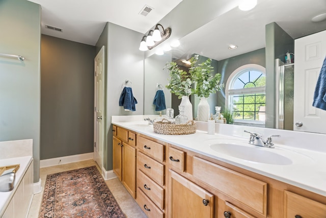 bathroom with tile patterned flooring, vanity, and a relaxing tiled tub