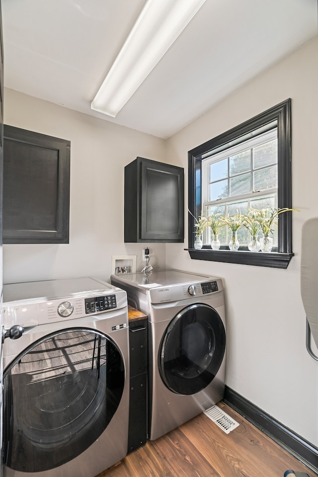 clothes washing area with washing machine and dryer and dark wood-type flooring