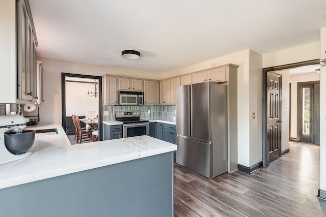 kitchen featuring sink, tasteful backsplash, dark hardwood / wood-style flooring, gray cabinets, and appliances with stainless steel finishes