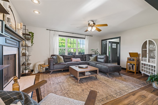 living room with ceiling fan and dark hardwood / wood-style flooring