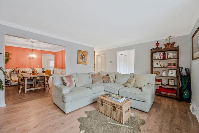 living room featuring crown molding and light wood-type flooring