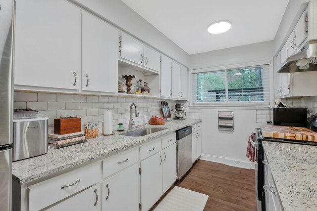 kitchen with white cabinetry, sink, dark hardwood / wood-style flooring, decorative backsplash, and appliances with stainless steel finishes