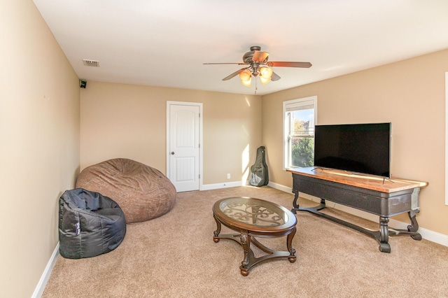 sitting room with carpet floors, visible vents, baseboards, and a ceiling fan