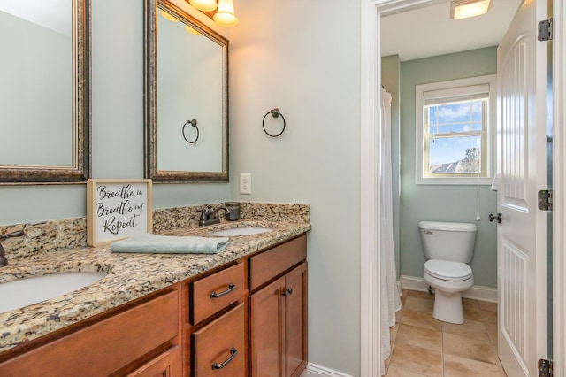 bathroom with double vanity, tile patterned flooring, baseboards, and a sink