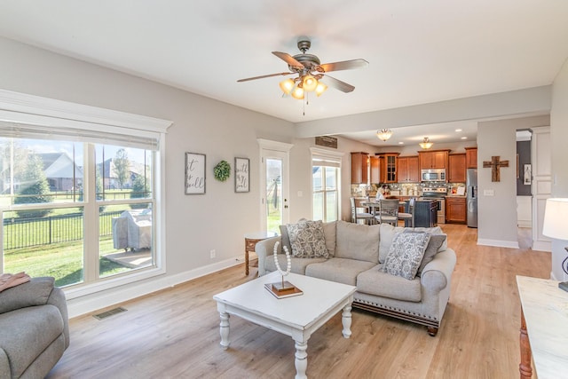 living room with recessed lighting, visible vents, light wood-style floors, a ceiling fan, and baseboards