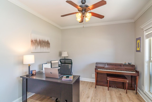 office space with light wood-style floors, ornamental molding, baseboards, and a ceiling fan