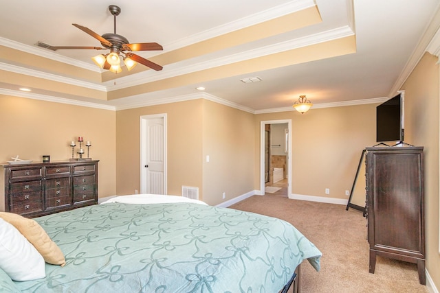 bedroom with a tray ceiling, light colored carpet, and visible vents