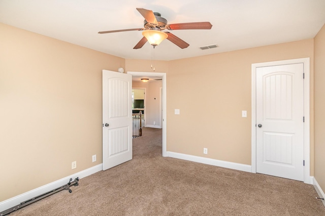 unfurnished bedroom featuring a ceiling fan, carpet, visible vents, and baseboards