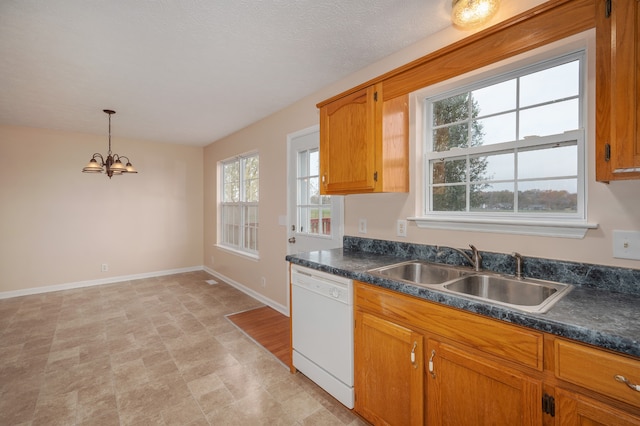 kitchen featuring pendant lighting, dishwasher, sink, and a wealth of natural light