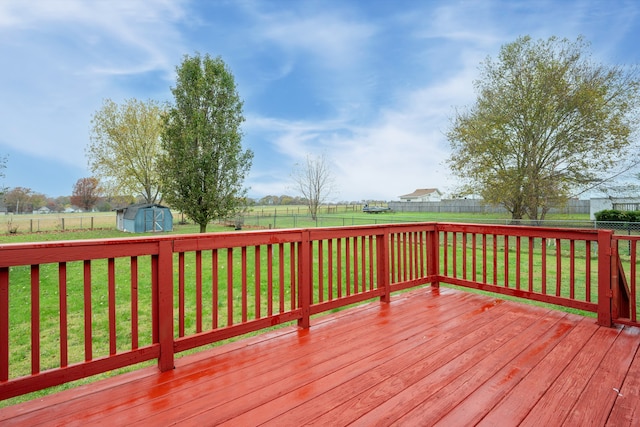 wooden deck with a storage shed and a yard