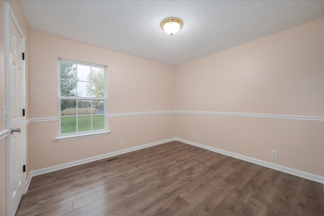 unfurnished room with wood-type flooring and a textured ceiling