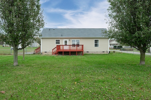 rear view of house featuring a yard and a deck