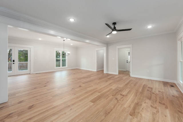 empty room with ceiling fan with notable chandelier, ornamental molding, french doors, and light hardwood / wood-style flooring