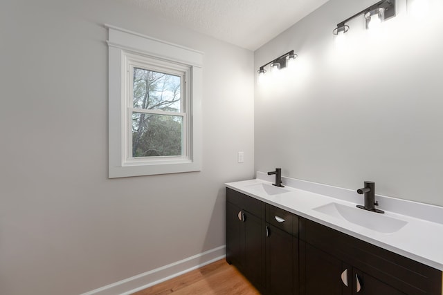 bathroom with hardwood / wood-style flooring, vanity, and a textured ceiling