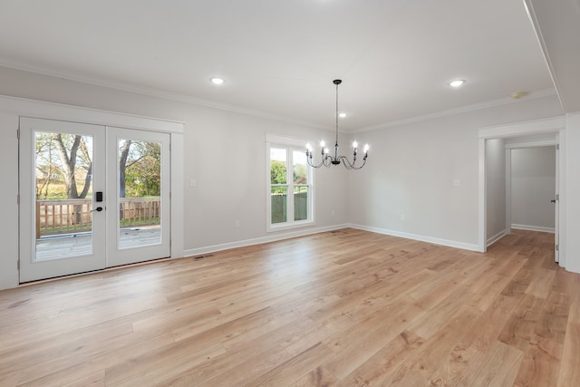 unfurnished dining area with light hardwood / wood-style flooring, ornamental molding, french doors, and an inviting chandelier