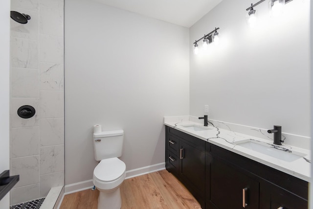 250 Bascom Rd, Jackson, TN 38305 - full bathroom featuring a tile shower, wood finished floors, double vanity, toilet, and baseboards