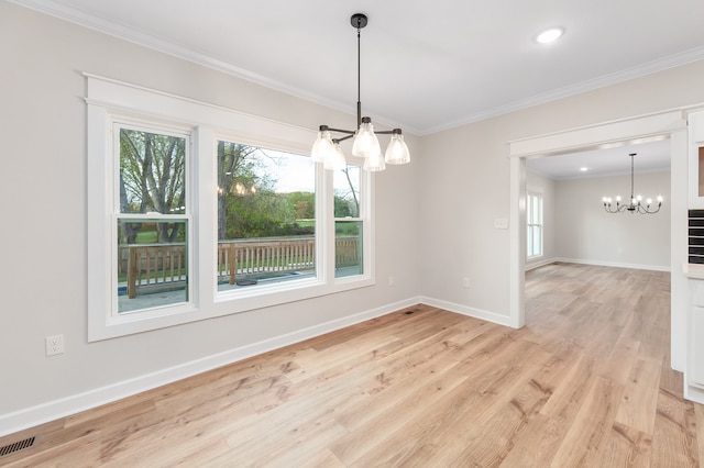 unfurnished dining area featuring light wood-type flooring, crown molding, a wealth of natural light, and an inviting chandelier