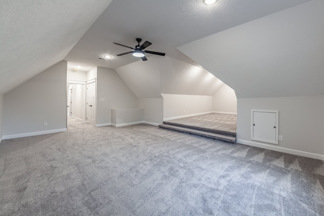 bonus room featuring a textured ceiling, ceiling fan, carpet, and lofted ceiling