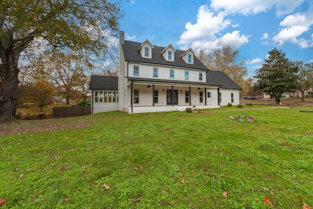 rear view of property featuring covered porch and a yard