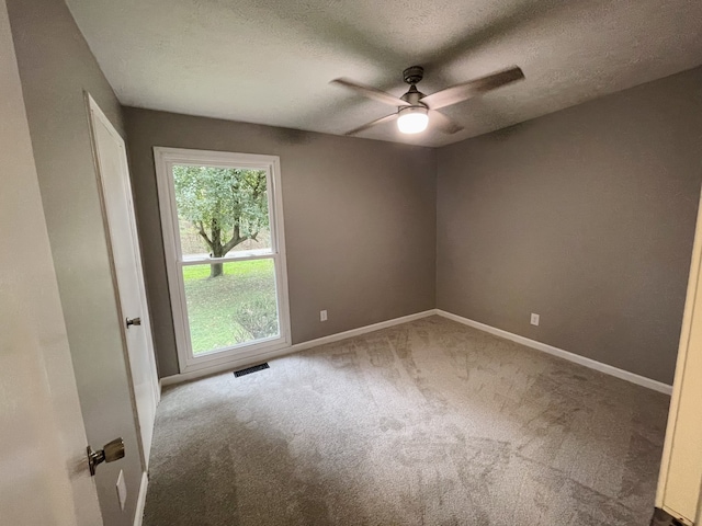 spare room with ceiling fan, carpet floors, and a textured ceiling